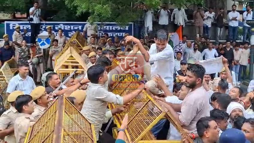 बैरिकेड पर चढ़ता एक कार्यकर्ता